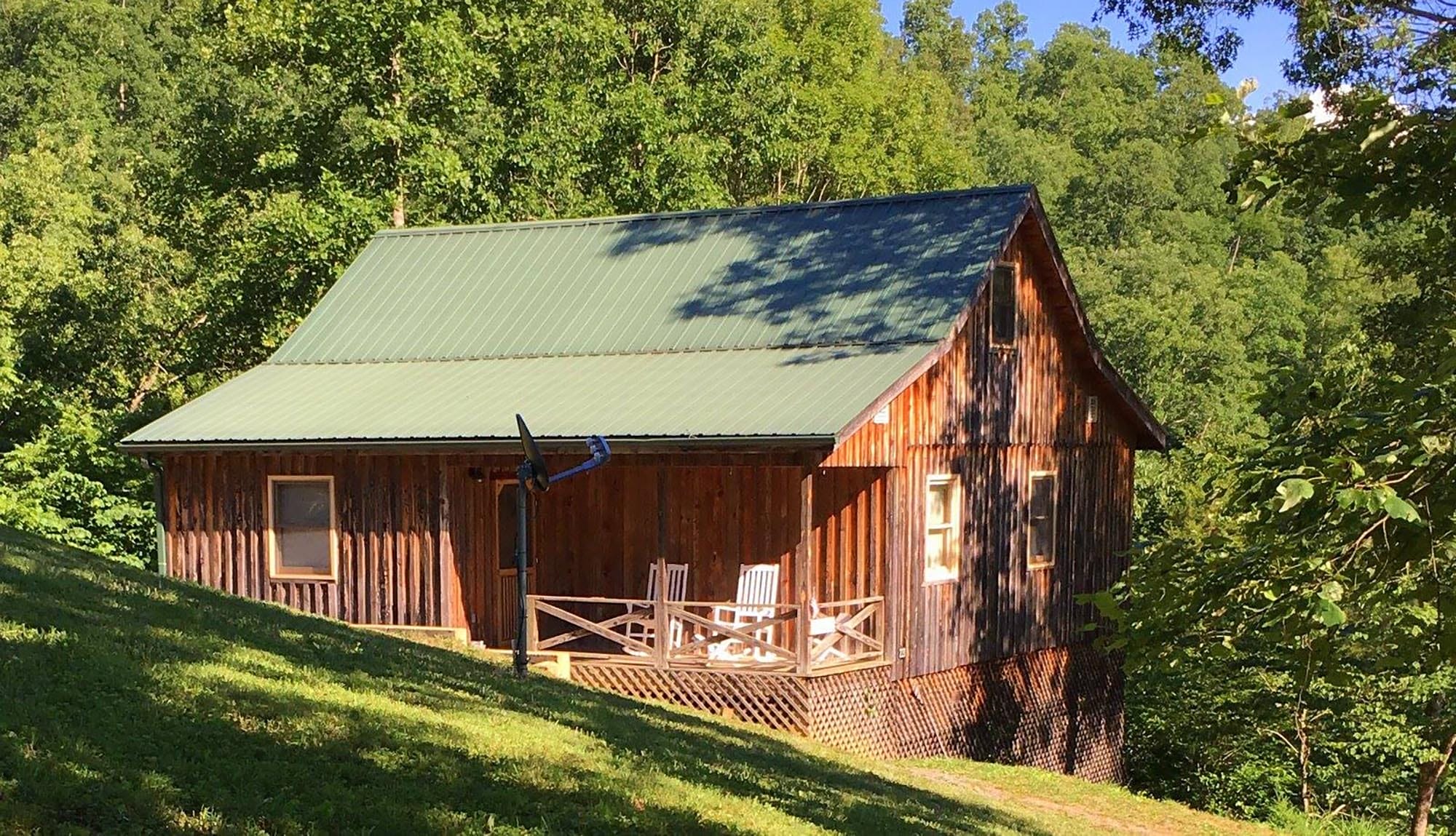 The outside of one of four handcrafted cabins by Appalachian Mountain Cabins with a front porch.